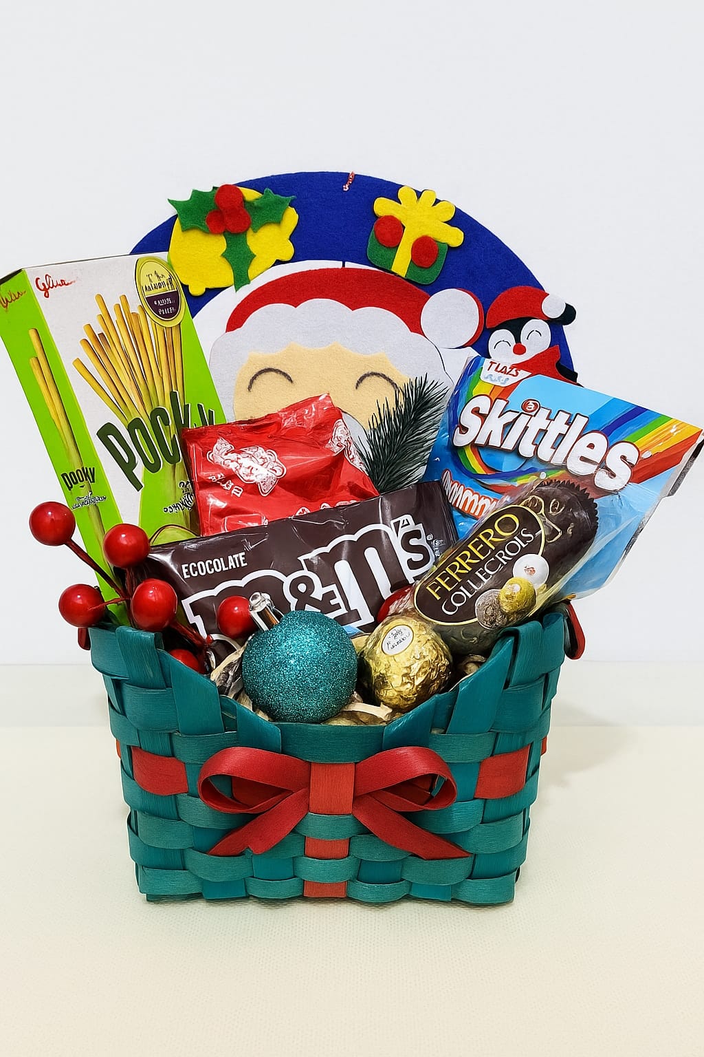 Green Christmas Treats Hamper Christmas hamper with matcha biscuits, chocolates, and gummies in a green festive basket