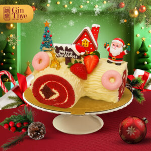 Gin Thye red velvet Christmas log cake with cream frosting, strawberries and Santa figurine