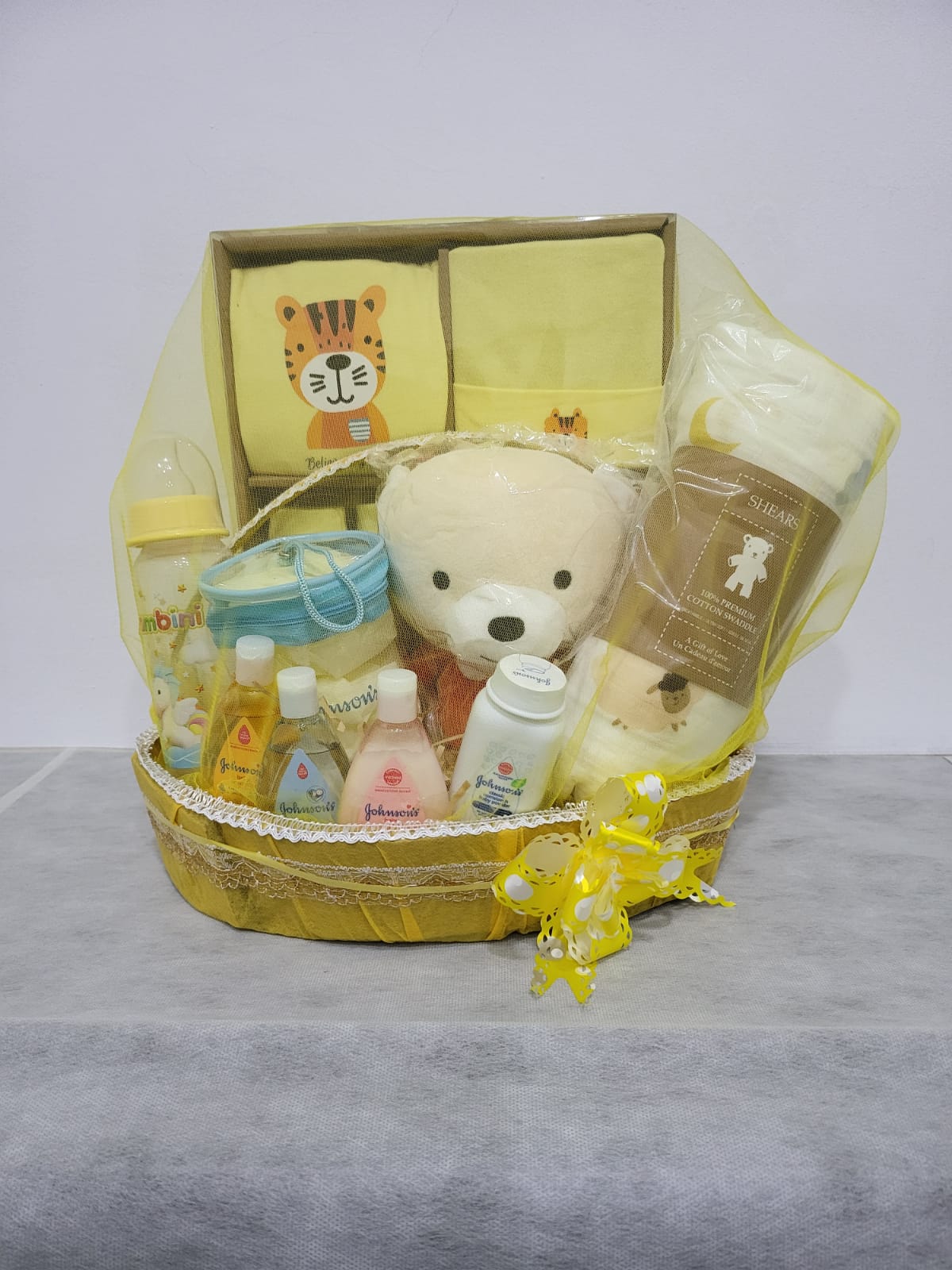 Gin Thye Baby Joy Hamper Yellow – Newborn Baby Shower Gift Yellow baby hamper by Gin Thye with Muji baby gift set, Johnson baby products, and premium cotton swaddle arranged in a yellow oval basket