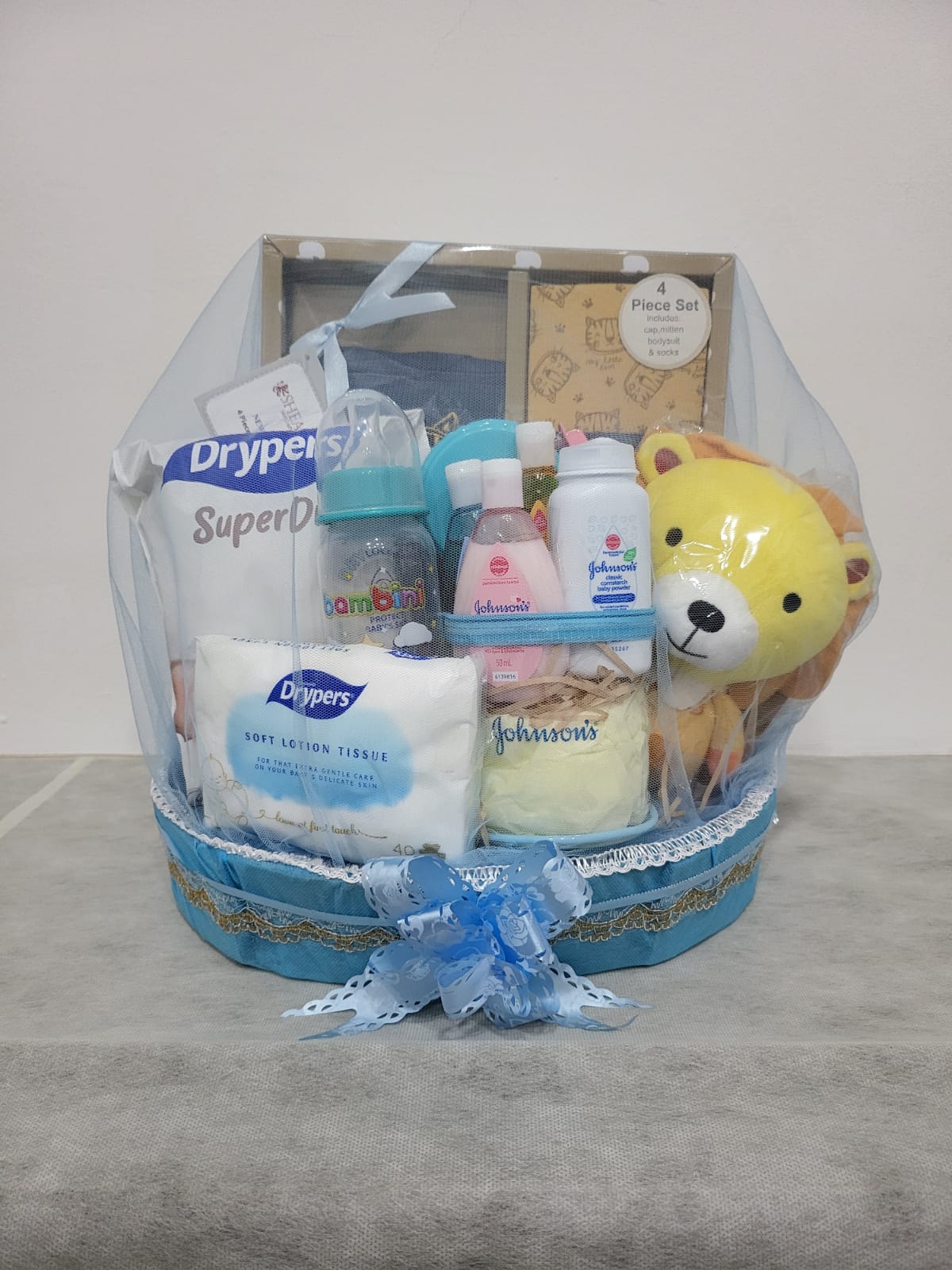 Gin Thye Baby Joy Hamper (Blue) - Newborn Baby Shower Gift Blue baby hamper from Gin Thye featuring Muji baby gift set, Johnson & Johnson products, and baby essentials in a yellow oval basket